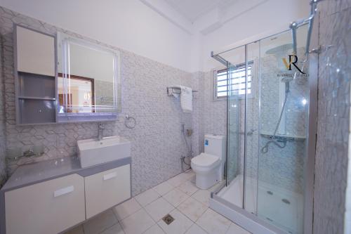 a bathroom with a shower and a sink and a toilet at Résidence Vinelly in Douala