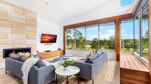 a living room with two couches and a fireplace at Jacoru On 3 in Pokolbin