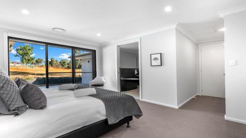 a bedroom with a large bed and a large window at The Residence in Pokolbin