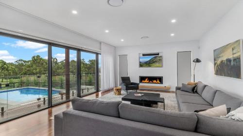 a living room with a couch and a fireplace at Villa Tallawanta in Pokolbin
