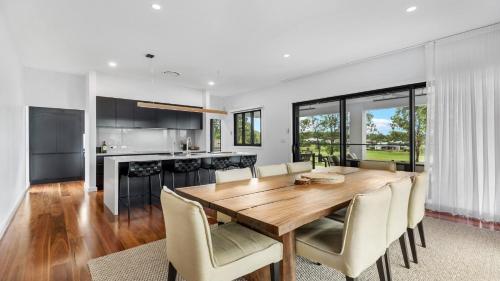 a kitchen and dining room with a wooden table and chairs at Villa Tallawanta in Pokolbin
