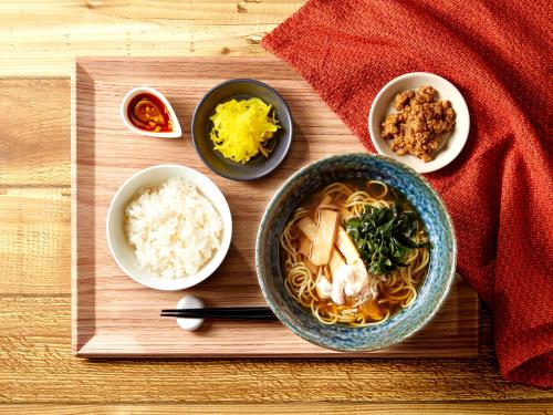 a wooden cutting board with a bowl of soup and rice at Keio Presso Inn Otemachi in Tokyo