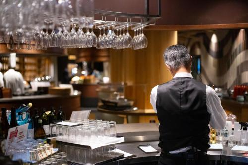 a man standing at a counter in a bar at Tsuetate Onsen Hotel Hizenya in Oguni
