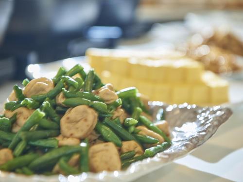 a plate of food with green beans and mushrooms at Keio Presso Inn Otemachi in Tokyo
