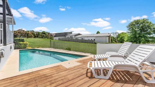 a patio with two chairs and a swimming pool at Olive Lakes in Pokolbin