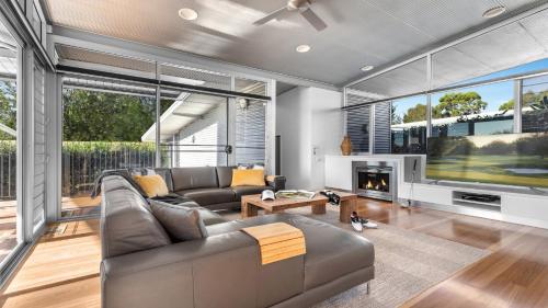 a living room with a couch and a tv at Olive Lakes in Pokolbin