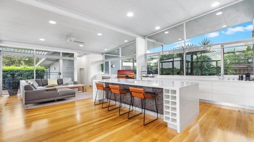 an open kitchen and living room with a bar and a couch at Olive Lakes in Pokolbin