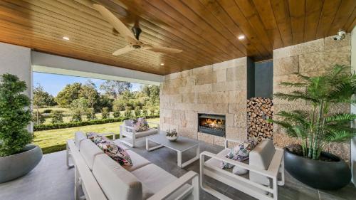 a living room with a stone wall and a fireplace at Hunter Valley Wildflower in Pokolbin