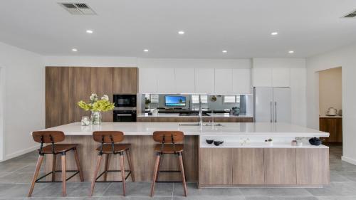 a kitchen with two bar stools and a counter top at Hunter Valley Wildflower in Pokolbin