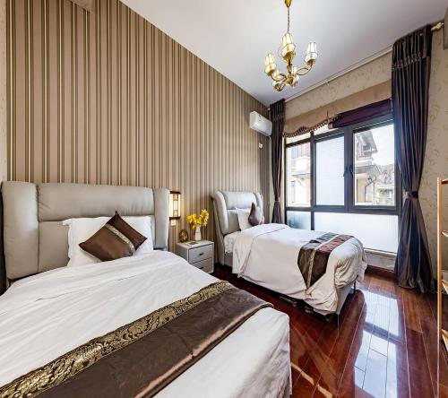 Habitación de hotel con 2 camas y lámpara de araña. en Annie Dianchi Lake Villas en Kunming