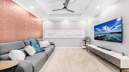 a living room with a couch and a painting on the wall at Willow's Green in Pokolbin