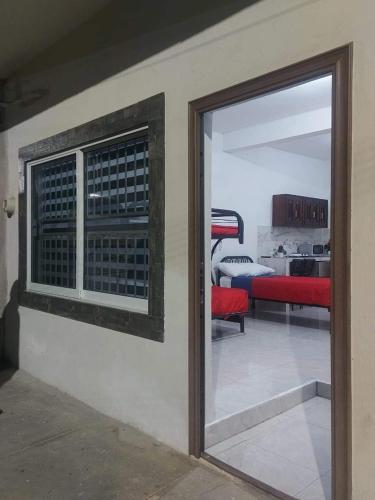 a room with a sliding glass door and a bedroom at DEPARTAMENTO PERLITA in Mazatlán