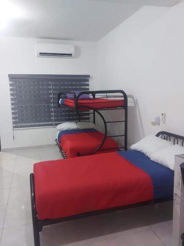 a room with two bunk beds with red and blue at DEPARTAMENTO PERLITA in Mazatlán