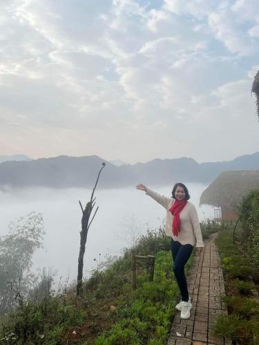 a woman standing on a path near a body of water at Hoàng Su Phì - Móng Ngựa Homestay in Ha Giang