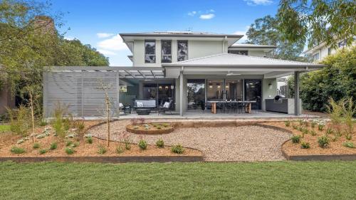 a house with a patio and a garden at Eucalypts in Pokolbin