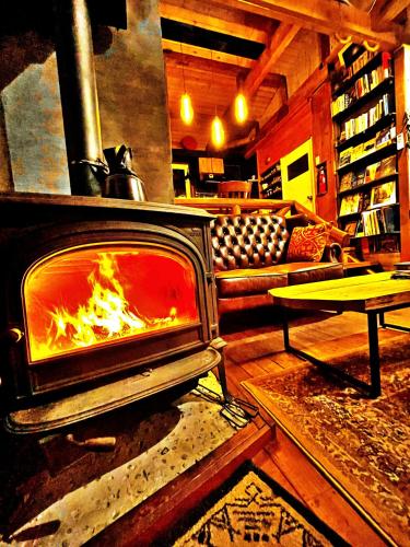 a fireplace in a living room with a fire at SHIZENTOYA Privete cottage for nature experience LakeView! in Lake Toya