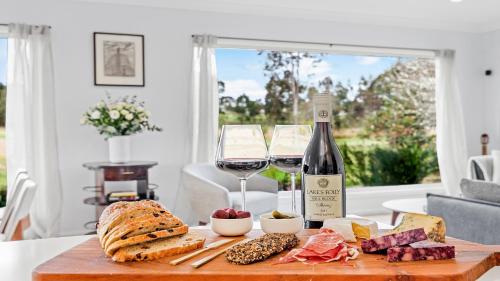 a table with a bottle of wine and a plate of food at 21 Forever in Pokolbin