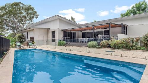 a house with a swimming pool in front of a house at The Clubhouse Pokolbin in Pokolbin