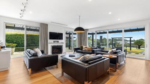 a living room with leather furniture and a fireplace at Belleview Hunter in Pokolbin