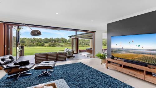a living room with a large flat screen tv at Peppertree Ponds in Pokolbin
