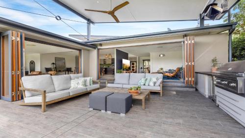 a patio with white furniture and a living room at Peppertree Ponds in Pokolbin