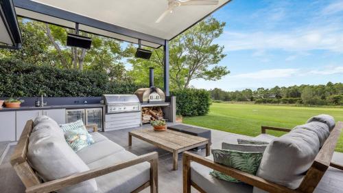 a patio with a couch and chairs and a stove at Peppertree Ponds in Pokolbin