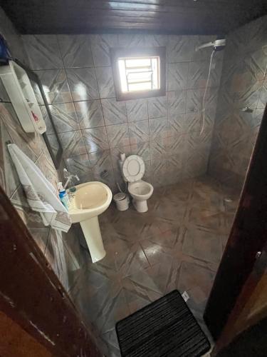 a small bathroom with a sink and a toilet at Suíte com sala de estar in Porto Velho