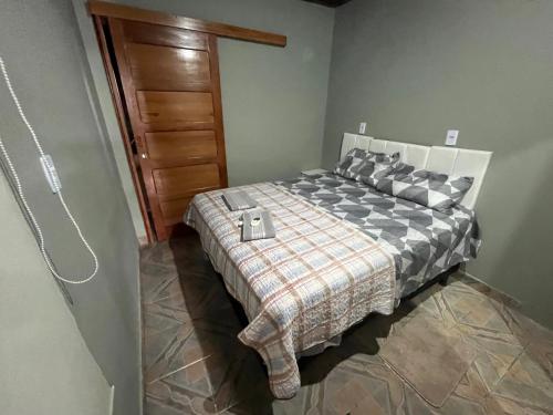 a bedroom with a bed and a wooden door at Suíte com sala de estar in Porto Velho