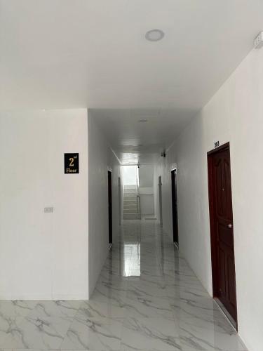an empty hallway with white walls and a door at DM ขอนแก่น โรงพยาบาลศรีนครินทร์ มข in Ban Nong Waeng