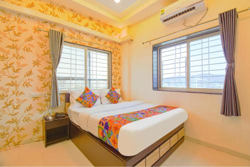 a small bedroom with a bed and two windows at GOLDEN LEAF PREMIUM HOTEL in Hinjewadi