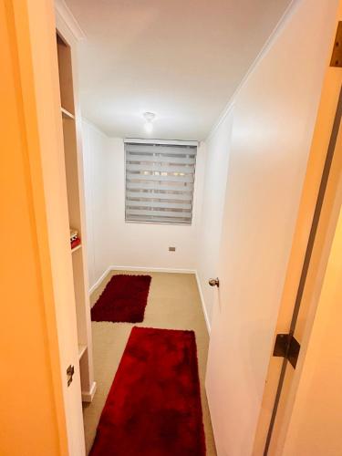 un corridoio con tappeto rosso e finestra di Departamento a La Chimba