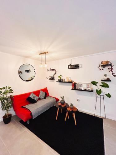 sala de estar con sofá rojo y alfombra negra en Departamento, en La Chimba