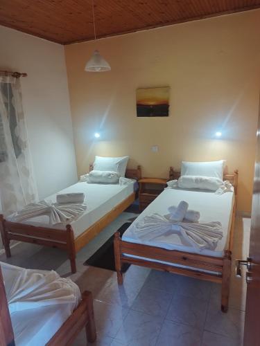 a room with two twin beds in it at Takis Haikos House two minutes walk to the beach Peroulia in Vounaria