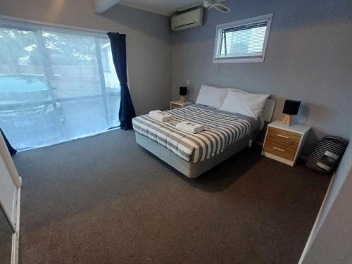 a bedroom with a bed and a large window at Aqua Apartment in Napier
