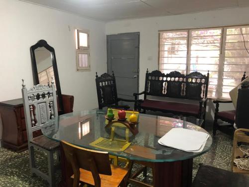 ein Wohnzimmer mit einem Glastisch und Stühlen in der Unterkunft Hostal Los Abuelos Colombianos in Cartagena de Indias