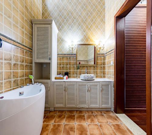 a bathroom with a tub and a sink and a mirror at Annie Dianchi Lake Villas in Kunming