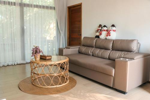 a living room with a couch and two snowmen at บ้านไร่มีสุข Baanrai Meesuk in Surat Thani