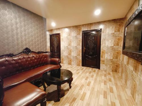 a living room with a leather couch and a table at HYDERS PARK- THE LUXURY HOTEL in Kodaikānāl