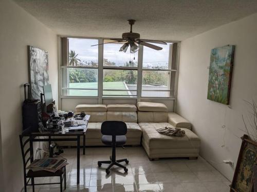 - un salon avec un canapé, une table et une fenêtre dans l'établissement Spacious gated 2 bed 2 bath with pool, à San Juan