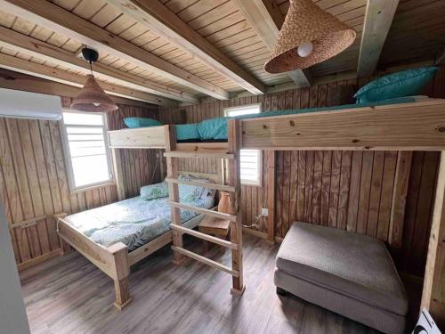 ein Schlafzimmer mit Etagenbetten in einer Holzhütte in der Unterkunft VSS Beach House - Arecibo in Arecibo