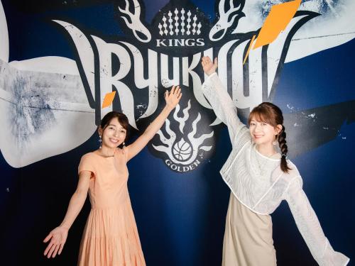 two girls standing next to each other with their hands in the air at REF Okinawa Arena by VESSEL HOTELS in Okinawa City