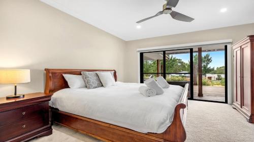 a bedroom with a bed and a ceiling fan at Wombat Lodge in Pokolbin