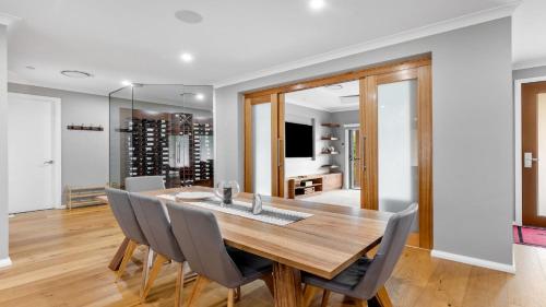 a dining room with a wooden table and chairs at Wombat Lodge in Pokolbin