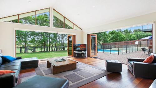 a living room with a couch and a tv at Eagles Landing - The Vintage in Pokolbin