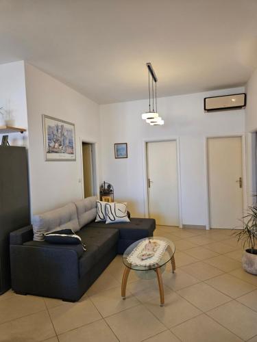 a living room with a black couch and a table at Villa Kety in Prigradica