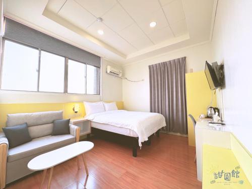 a hotel room with a bed and a couch at Green Island Sweet Hotel in Green Island