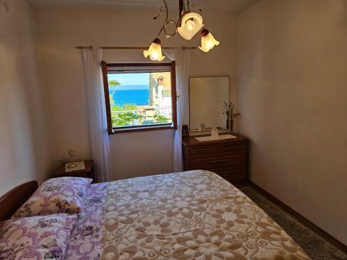 a bedroom with a bed and a mirror and a window at Villa Kety in Prigradica