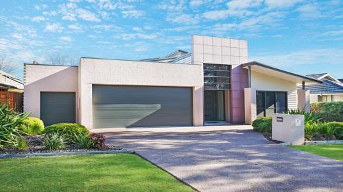 ein Haus mit einer Garage und einer Auffahrt in der Unterkunft Villa Saachi - The Vintage in Pokolbin