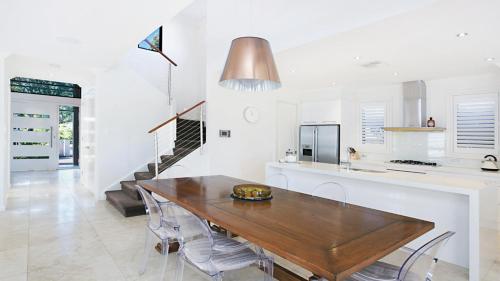 a kitchen and dining room with a wooden table at Villa Saachi - The Vintage in Pokolbin