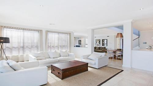 a white living room with white couches and a table at Villa Saachi - The Vintage in Pokolbin